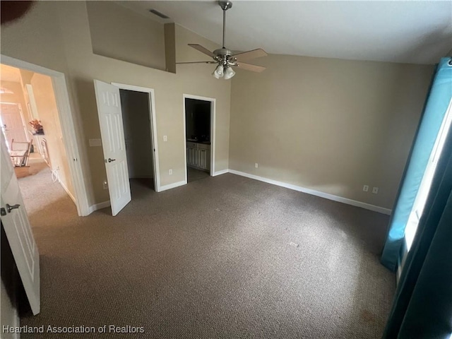 unfurnished bedroom featuring connected bathroom, ceiling fan, high vaulted ceiling, and dark carpet