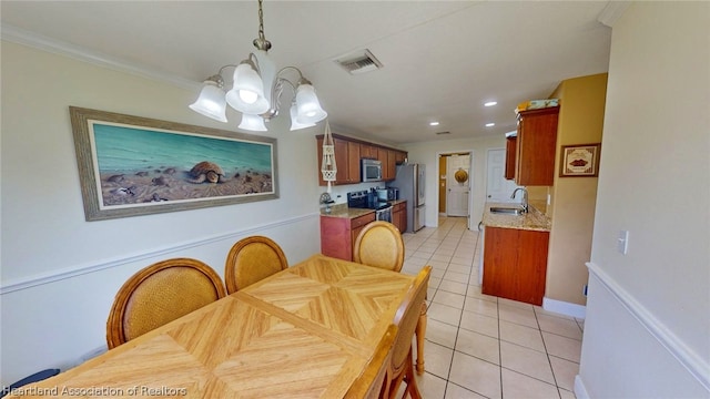 dining space featuring light tile patterned flooring, ornamental molding, sink, and a chandelier