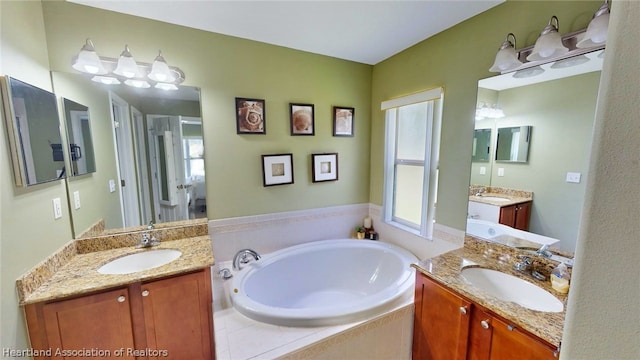 bathroom featuring vanity and tiled tub