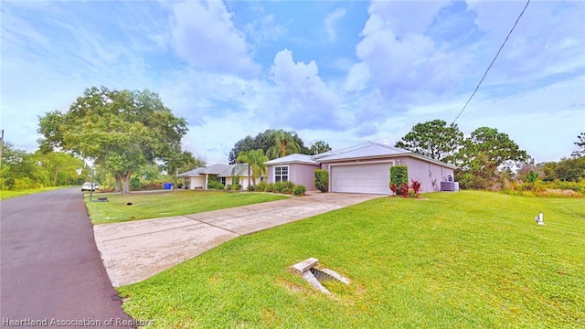 ranch-style home featuring central AC unit, a front yard, and a garage