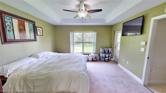 bedroom featuring a raised ceiling and ceiling fan