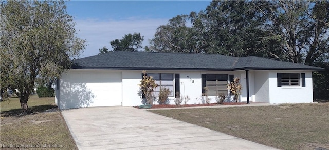 single story home featuring a garage and a front lawn