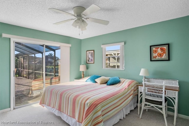 carpeted bedroom with ceiling fan, access to exterior, and a textured ceiling