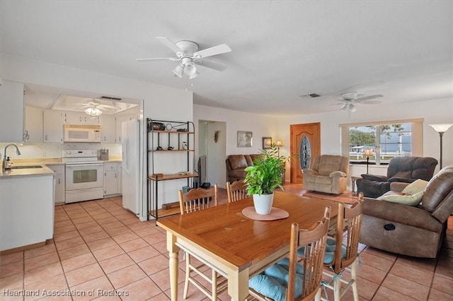 dining room featuring ceiling fan, sink, and light tile patterned floors