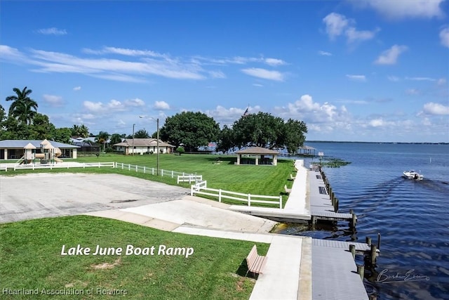 view of dock with a water view and a yard