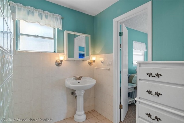 bathroom with tile walls, tile patterned floors, and a textured ceiling