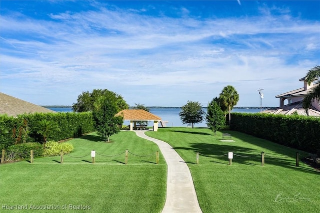 surrounding community with a gazebo, a water view, and a lawn