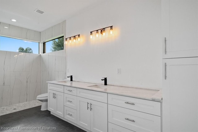 bathroom featuring tile patterned flooring, vanity, and toilet