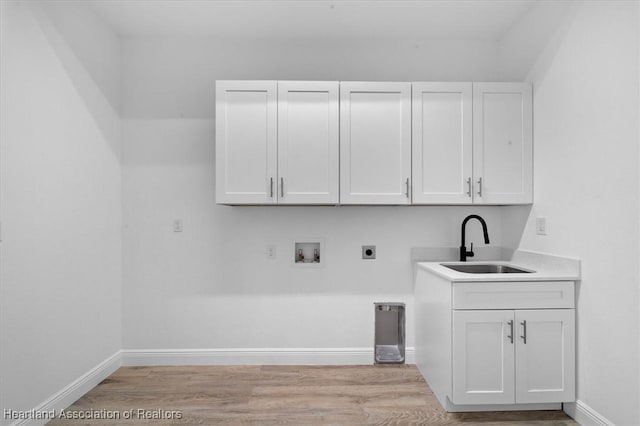 washroom with sink, hookup for a washing machine, cabinets, light hardwood / wood-style floors, and hookup for an electric dryer