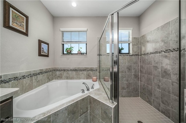 bathroom with vanity and shower with separate bathtub