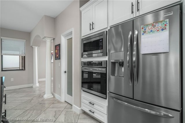 kitchen featuring stainless steel appliances, white cabinets, and ornate columns