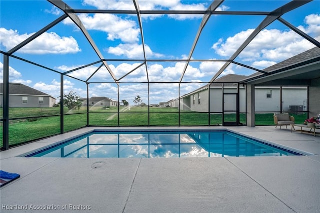 view of pool with a yard, a patio, and glass enclosure