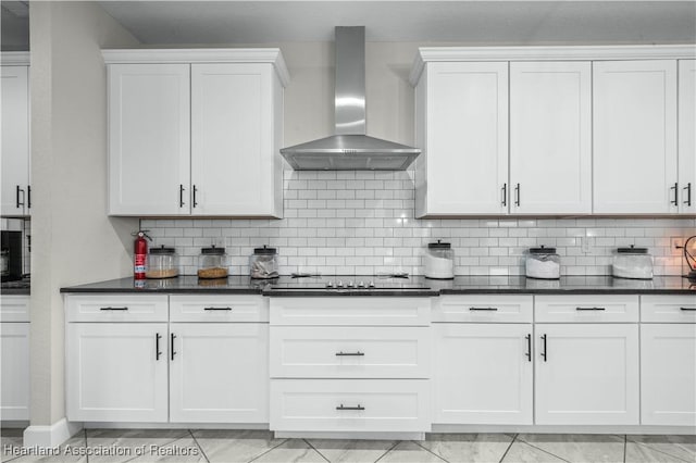 kitchen with white cabinetry, black electric cooktop, backsplash, and wall chimney range hood