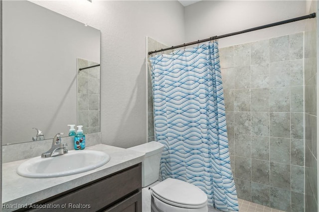 bathroom featuring a shower with curtain, vanity, and toilet