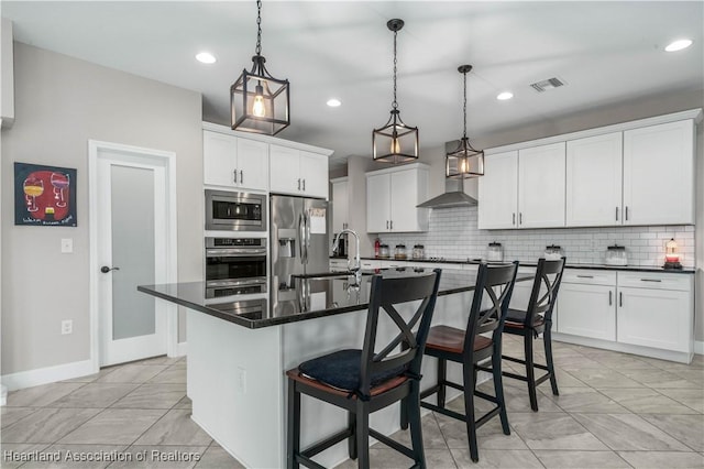 kitchen featuring pendant lighting, sink, white cabinets, a kitchen island with sink, and stainless steel appliances