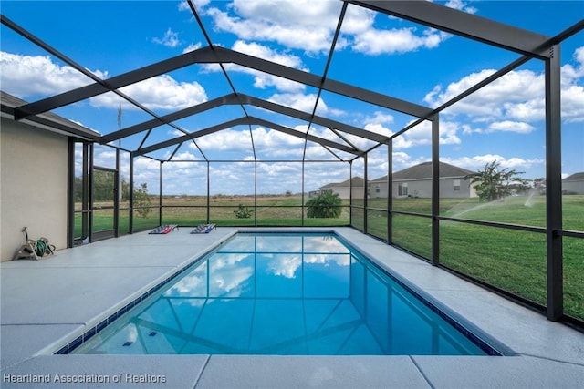 view of pool with a patio, glass enclosure, and a lawn