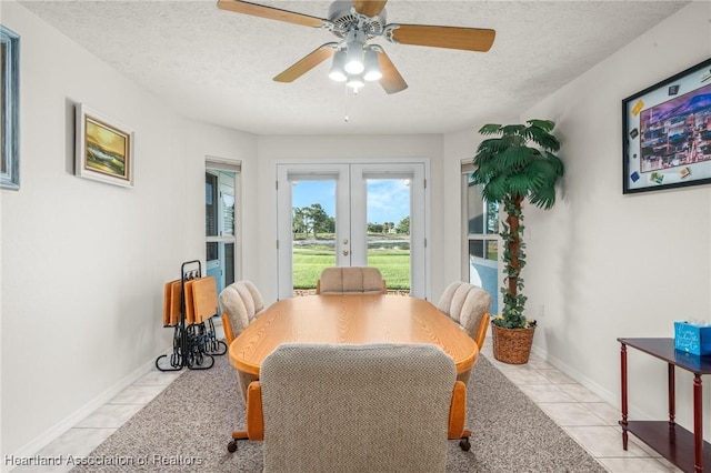 dining room featuring ceiling fan, french doors, light tile patterned floors, and a textured ceiling