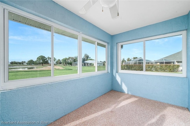 unfurnished sunroom with ceiling fan and a wealth of natural light