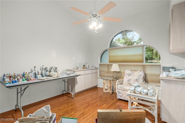 living area with ceiling fan and light hardwood / wood-style flooring