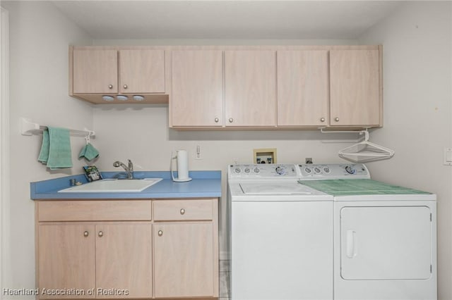 laundry room featuring cabinets, sink, and washing machine and clothes dryer