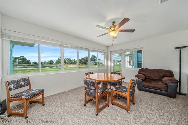 dining area featuring ceiling fan and light colored carpet