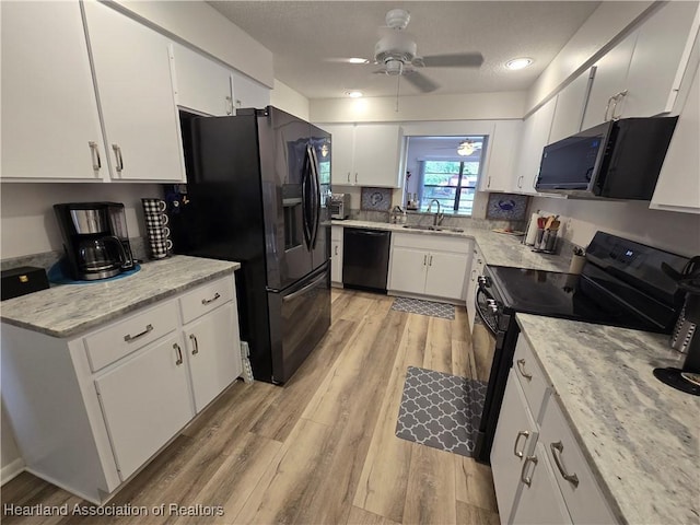 1725 Amber Ln, Lake Placid, FL 33852 - kitchen with black appliances, ceiling fan, light wood-style flooring, and white cabinets
