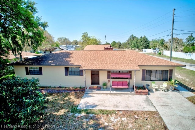 single story home with a patio area, a shingled roof, fence, and stucco siding