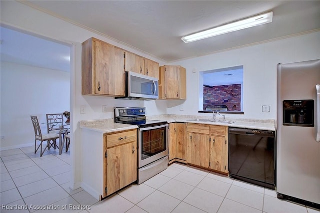 kitchen featuring light tile patterned floors, light countertops, appliances with stainless steel finishes, ornamental molding, and a sink