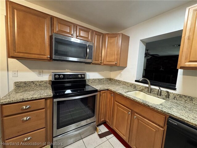 1341 Lake Clay Dr, Lake Placid, FL 33852 - kitchen featuring appliances with stainless steel finishes, a sink, ceiling fan, light stone counters, and light tile patterned floors