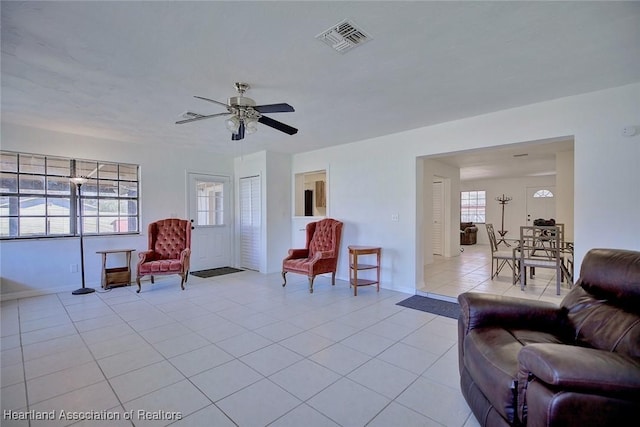 living area featuring visible vents, ceiling fan, baseboards, and light tile patterned floors