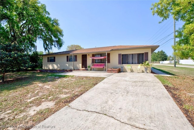 single story home with a front lawn and stucco siding