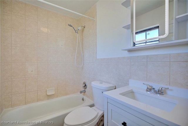 bathroom featuring washtub / shower combination, vanity, toilet, and tile walls