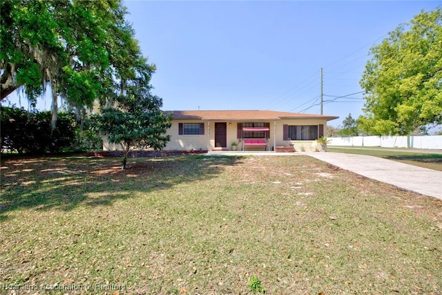 ranch-style home with stucco siding, fence, and a front yard