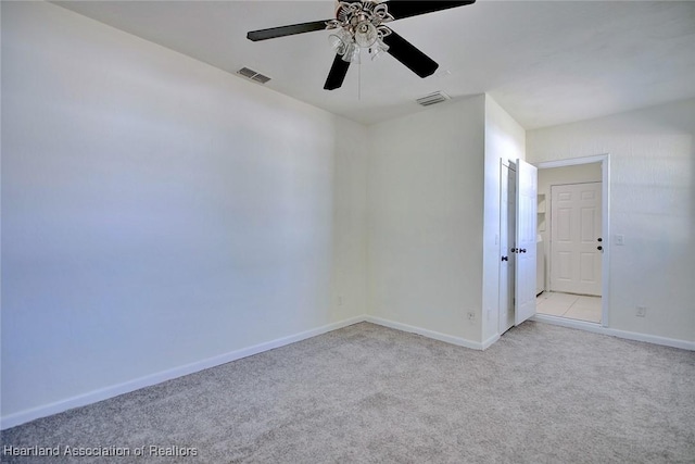 unfurnished room featuring carpet flooring, ceiling fan, visible vents, and baseboards