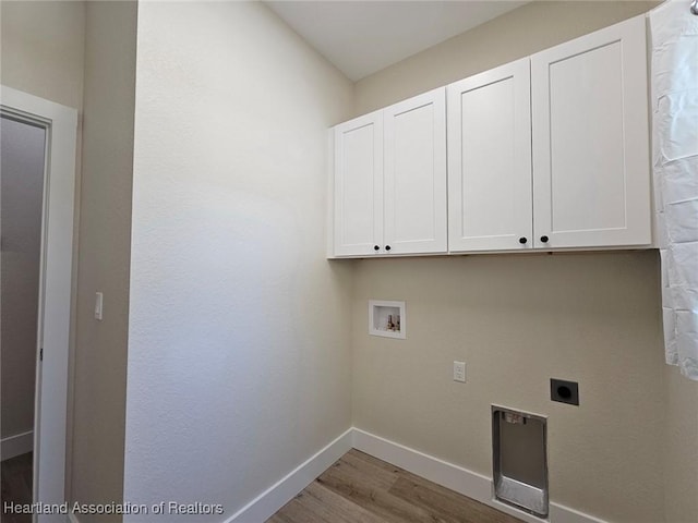laundry room featuring electric dryer hookup, baseboards, hookup for a washing machine, cabinet space, and wood finished floors