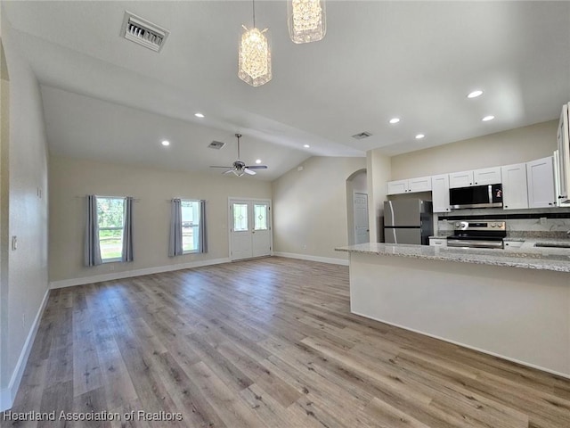 kitchen featuring vaulted ceiling, visible vents, ceiling fan, stainless steel appliances, and arched walkways