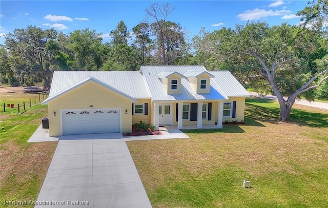 view of front facade featuring driveway, a front lawn, central AC unit, a garage, and metal roof