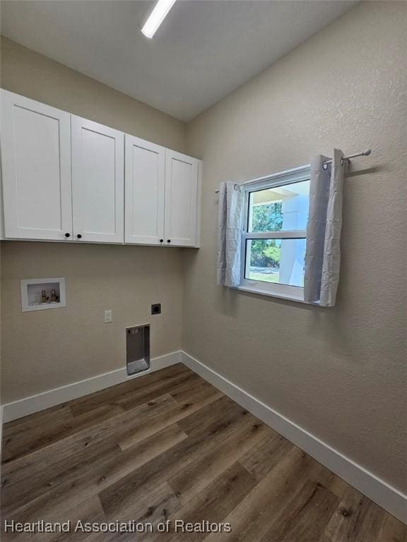 clothes washing area featuring baseboards, washer hookup, dark wood-type flooring, hookup for an electric dryer, and cabinet space