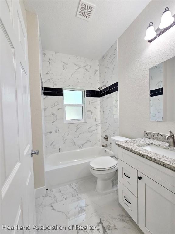bathroom featuring washtub / shower combination, vanity, toilet, visible vents, and marble finish floor