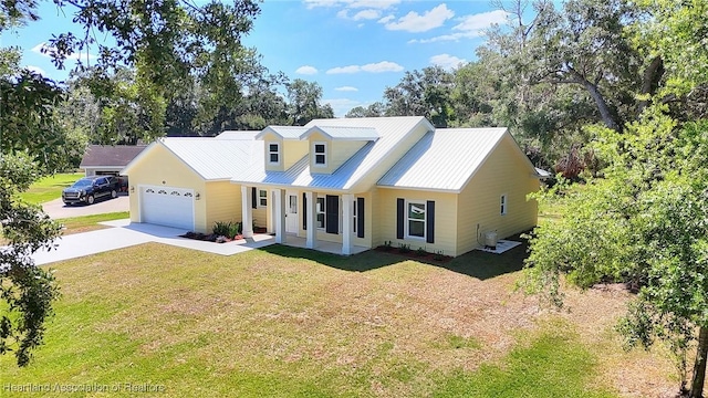 view of front facade featuring an attached garage, a front lawn, driveway, and metal roof
