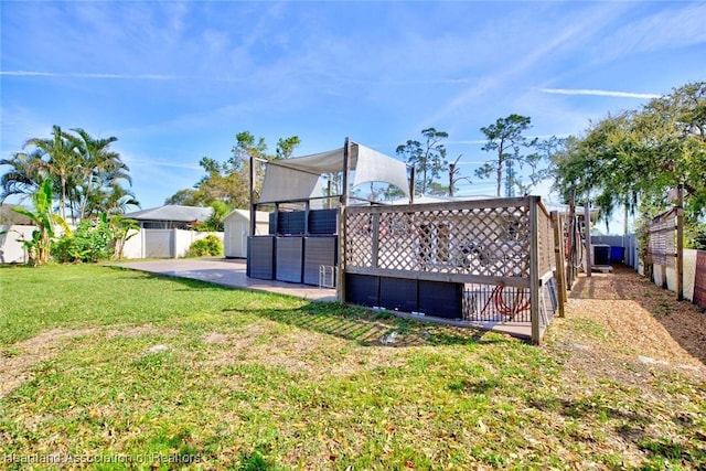 view of yard with a patio, a storage unit, an outdoor structure, and a fenced backyard