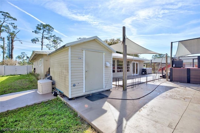 view of shed featuring fence and an outdoor hangout area