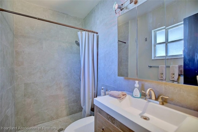 bathroom featuring tiled shower, backsplash, vanity, and tile walls