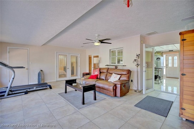 living area with french doors, light tile patterned flooring, visible vents, and a ceiling fan