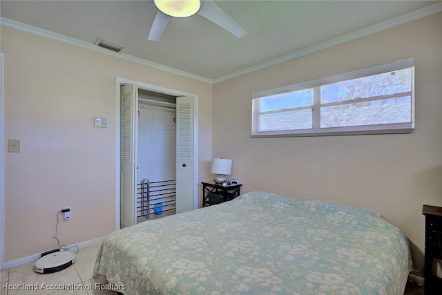 tiled bedroom with baseboards, visible vents, a ceiling fan, ornamental molding, and a closet