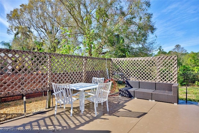 view of patio / terrace featuring outdoor dining area, fence, and an outdoor living space