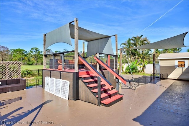 view of playground featuring fence, an outdoor hangout area, and a patio