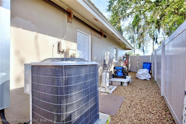 exterior details featuring a fenced backyard, central AC, and stucco siding