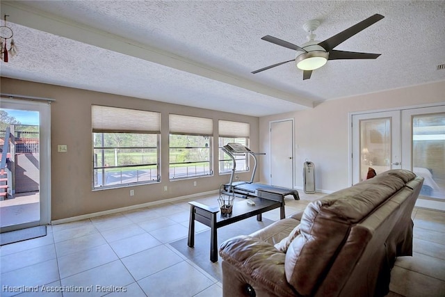 living room with light tile patterned floors, visible vents, baseboards, a ceiling fan, and french doors