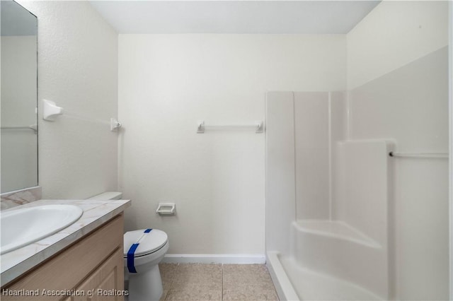 bathroom with tile patterned flooring, vanity, toilet, and walk in shower